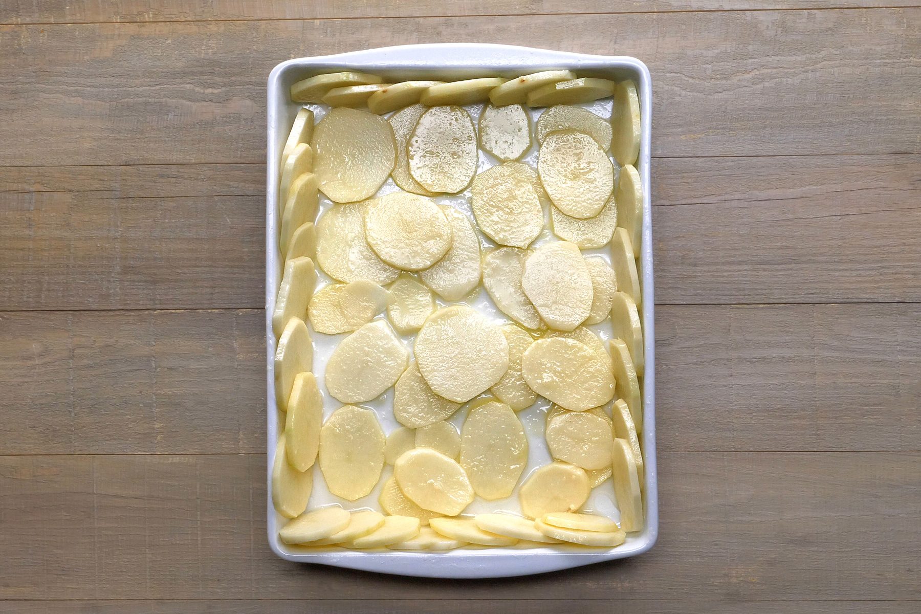 Top shot of potato slices in baking tray